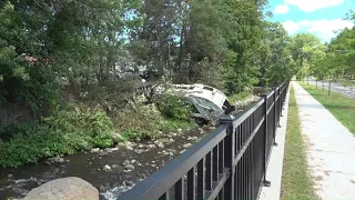 Garbage truck crashes off road into Bristol river, injuring 2 people