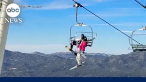 Skier dangles from chairlift
