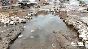 Rua alagada no bairro dos Remédios revolta moradores em Cajazeiras: "Em tempo de cair nos buracos"