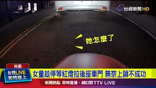 The girl tried to lock the back door of the car while it was stopped at a red light, but failed.