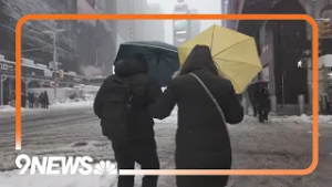 People in Times Square walking through snow during winter storm