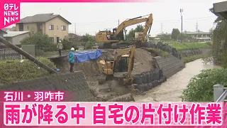 【石川・羽咋市】雨が降る中、自宅の片付け作業  JR七尾線、来月6日の運転再開目指す